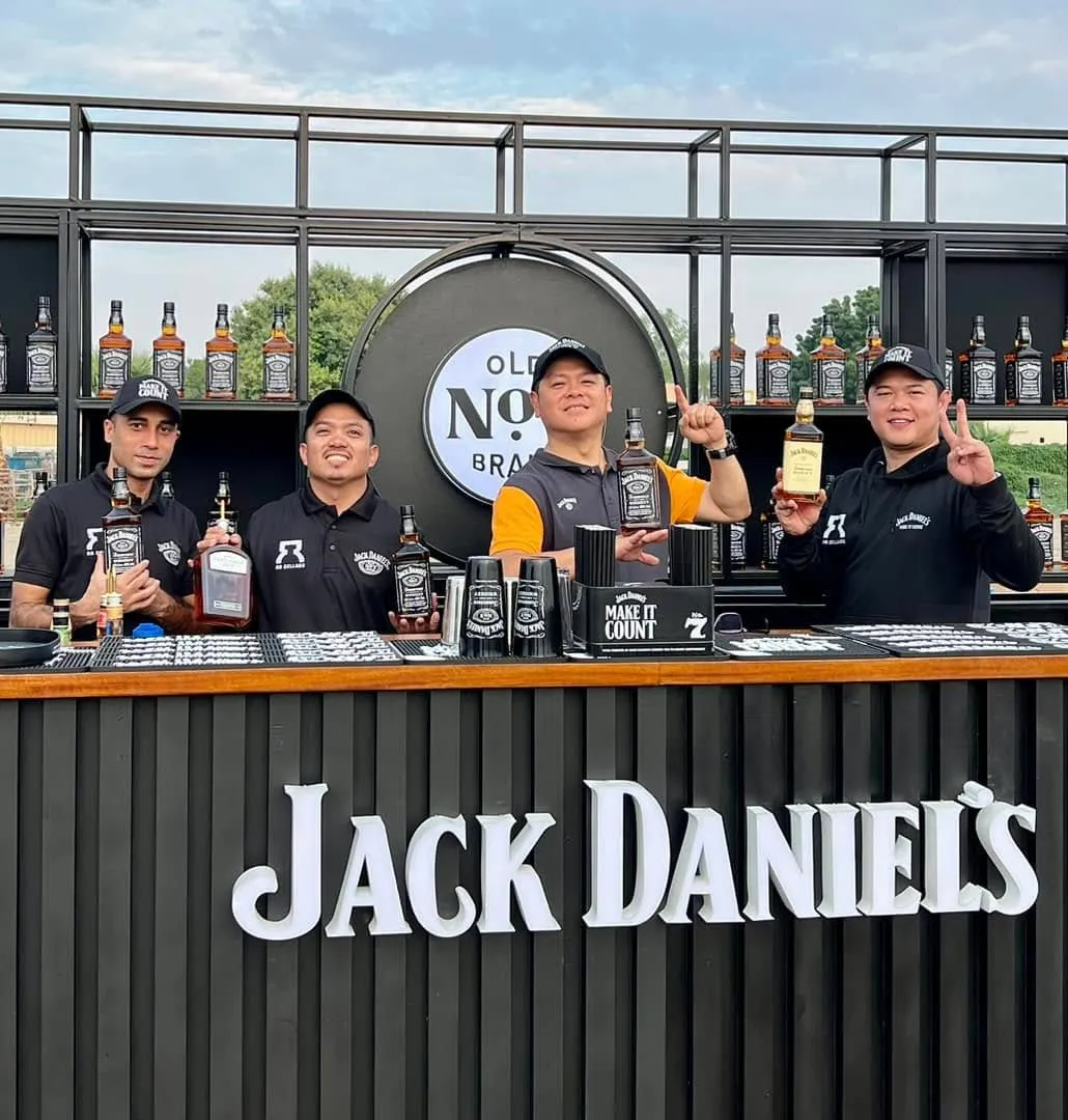 A VIBE bar team smiling behind a fully stocked activation bar
