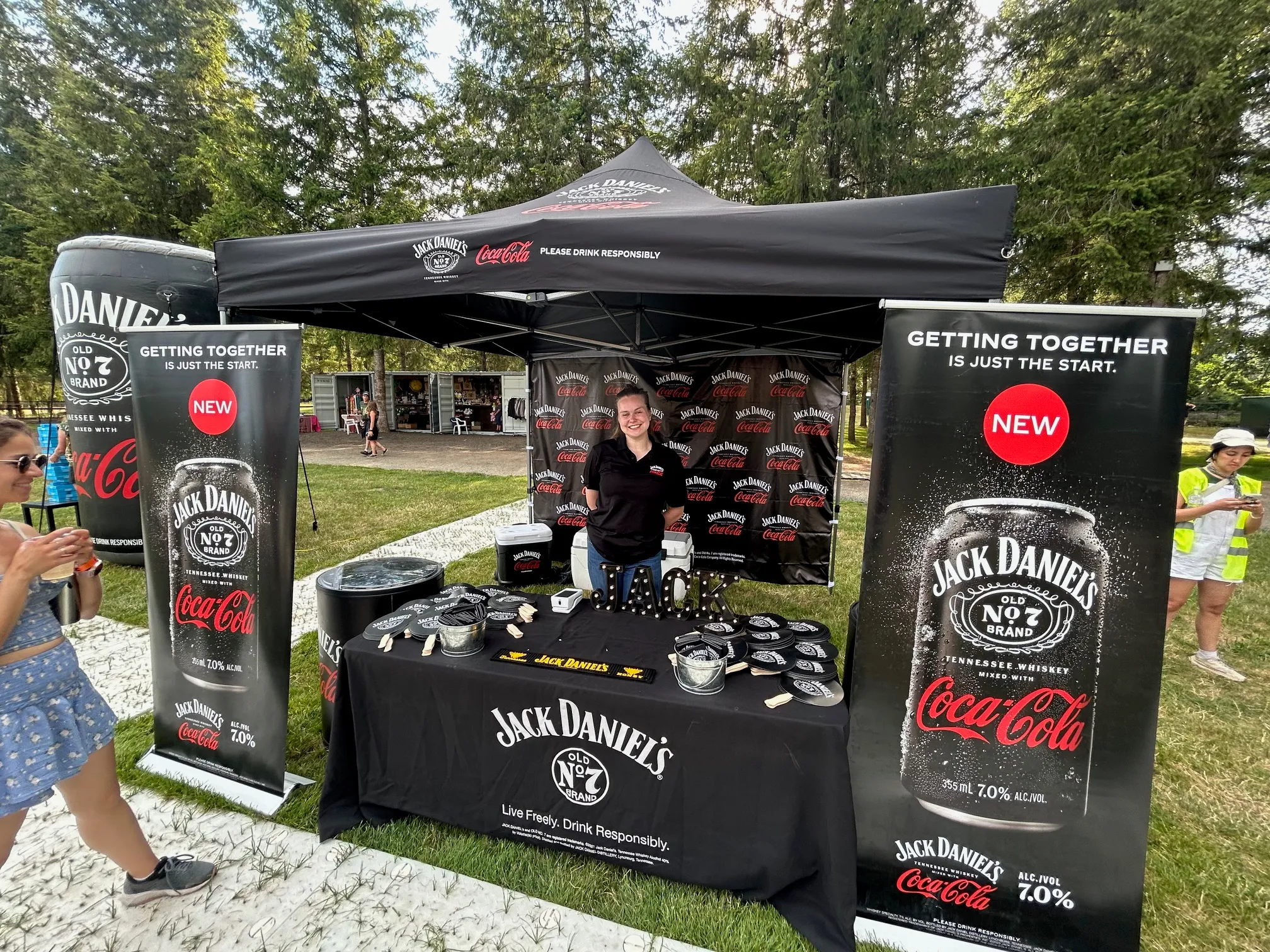 Jack Daniel's & Coca-Cola sampling booth with a VIBE brand ambassador at an outdoor festival